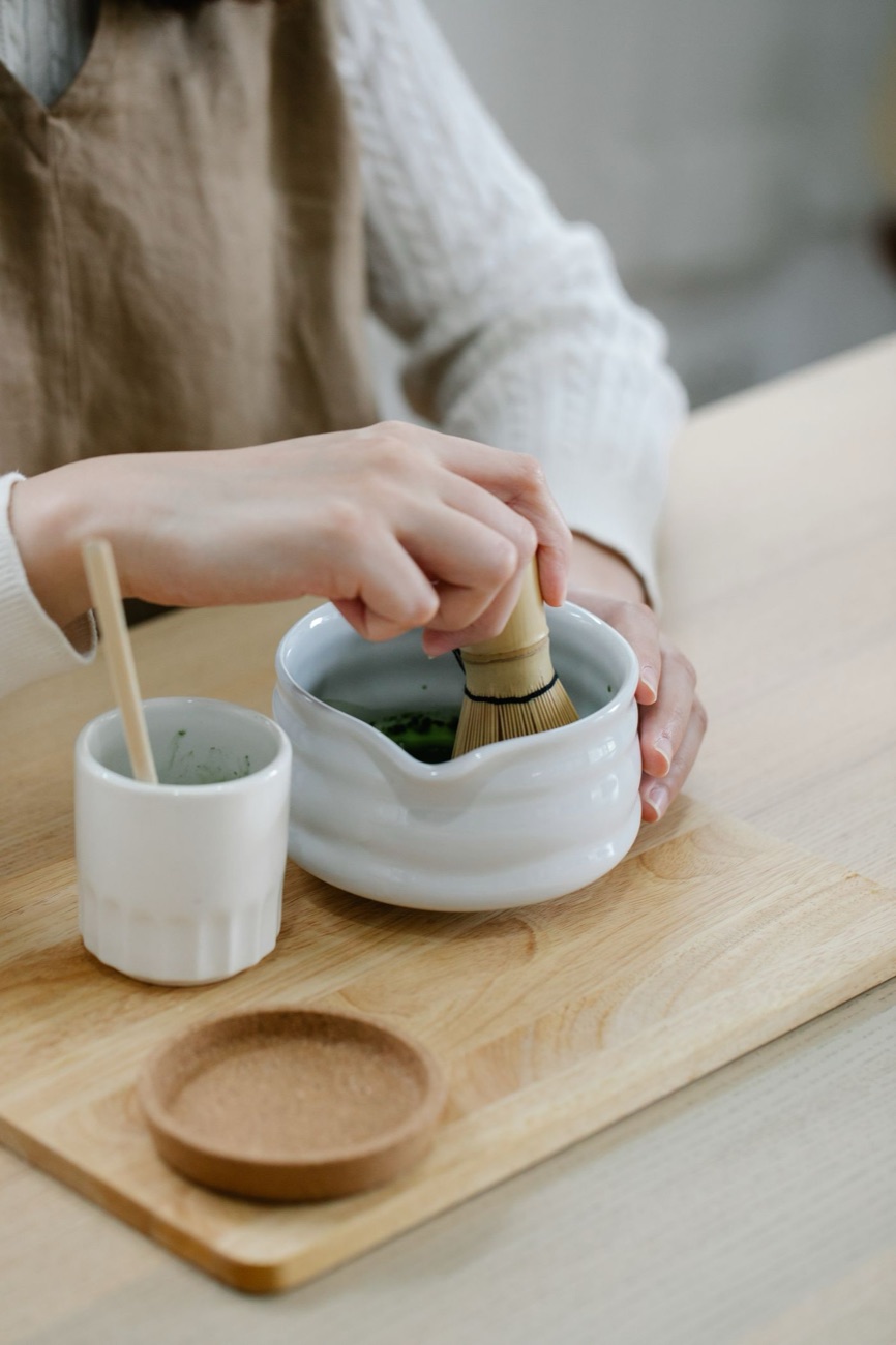 Matcha vispas för hand med en bambuvisp i en keramikskål